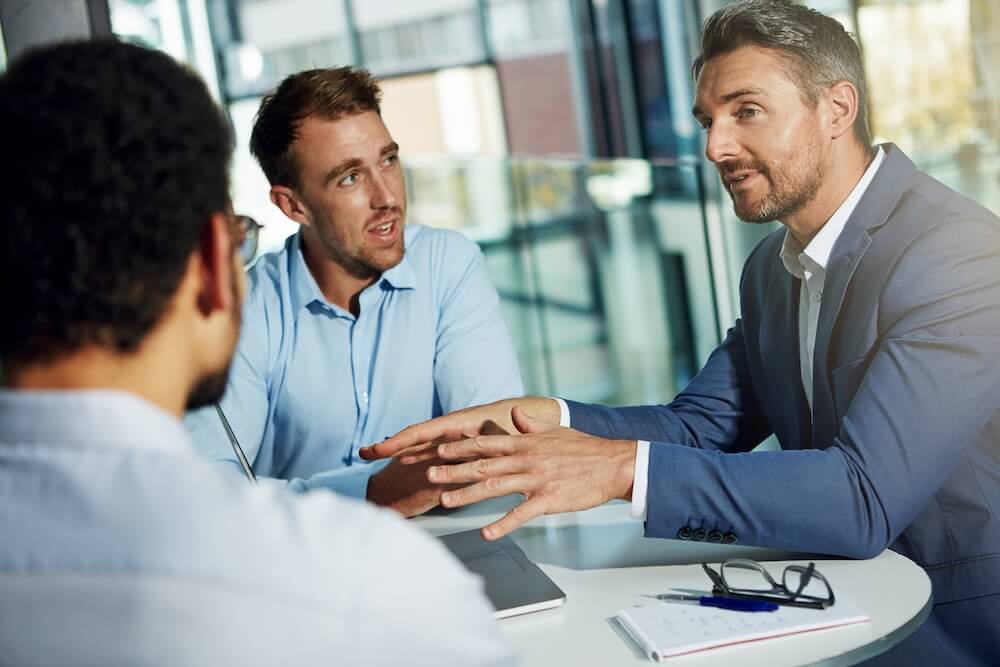3 men talking about M&A deal and the future success of the bussiness